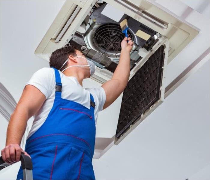 A man cleaning air conditioning